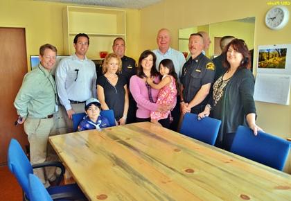 Supervisor Couch, Fire Chief Marshall, 4th District Staff, Chamber Executive Rachel Unell, Chamber Board, and Rachel’s kids pose in front of re-purposed table